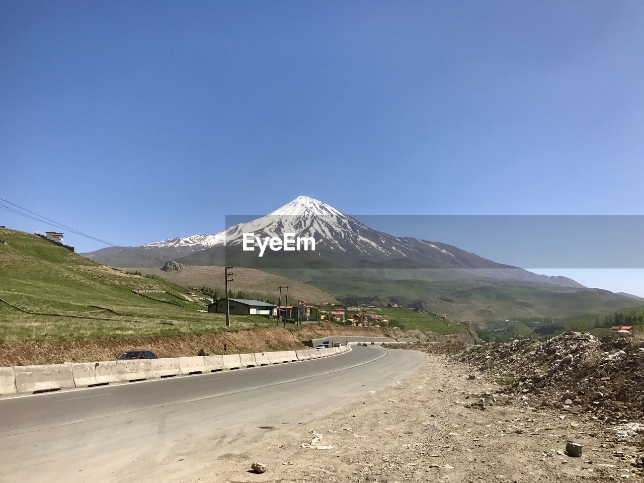 ROAD BY SNOWCAPPED MOUNTAIN AGAINST BLUE SKY