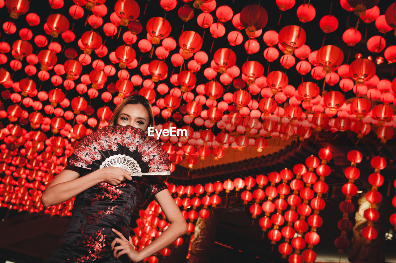 Portrait of young woman in city during chinese lantern festival at night