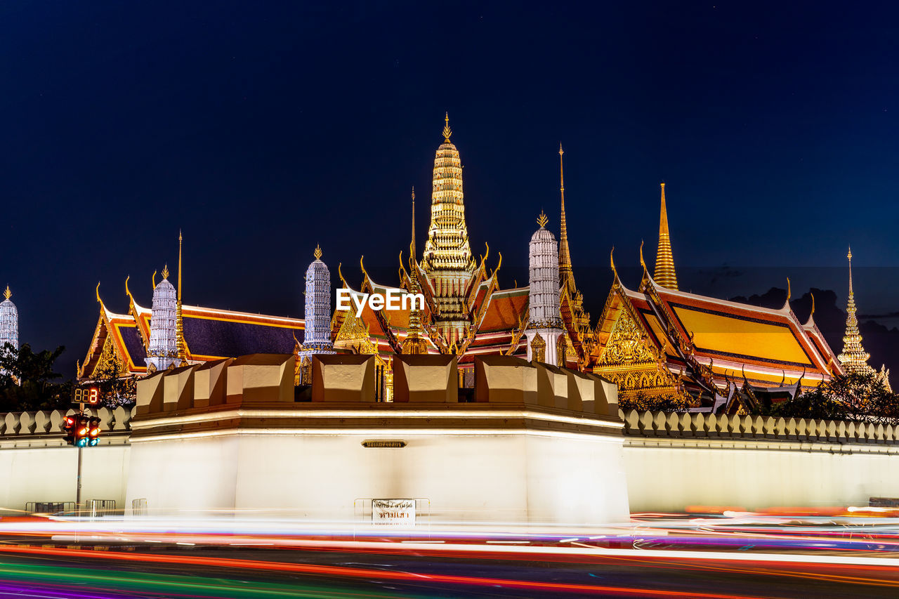 TEMPLE BY BUILDING AGAINST SKY AT NIGHT