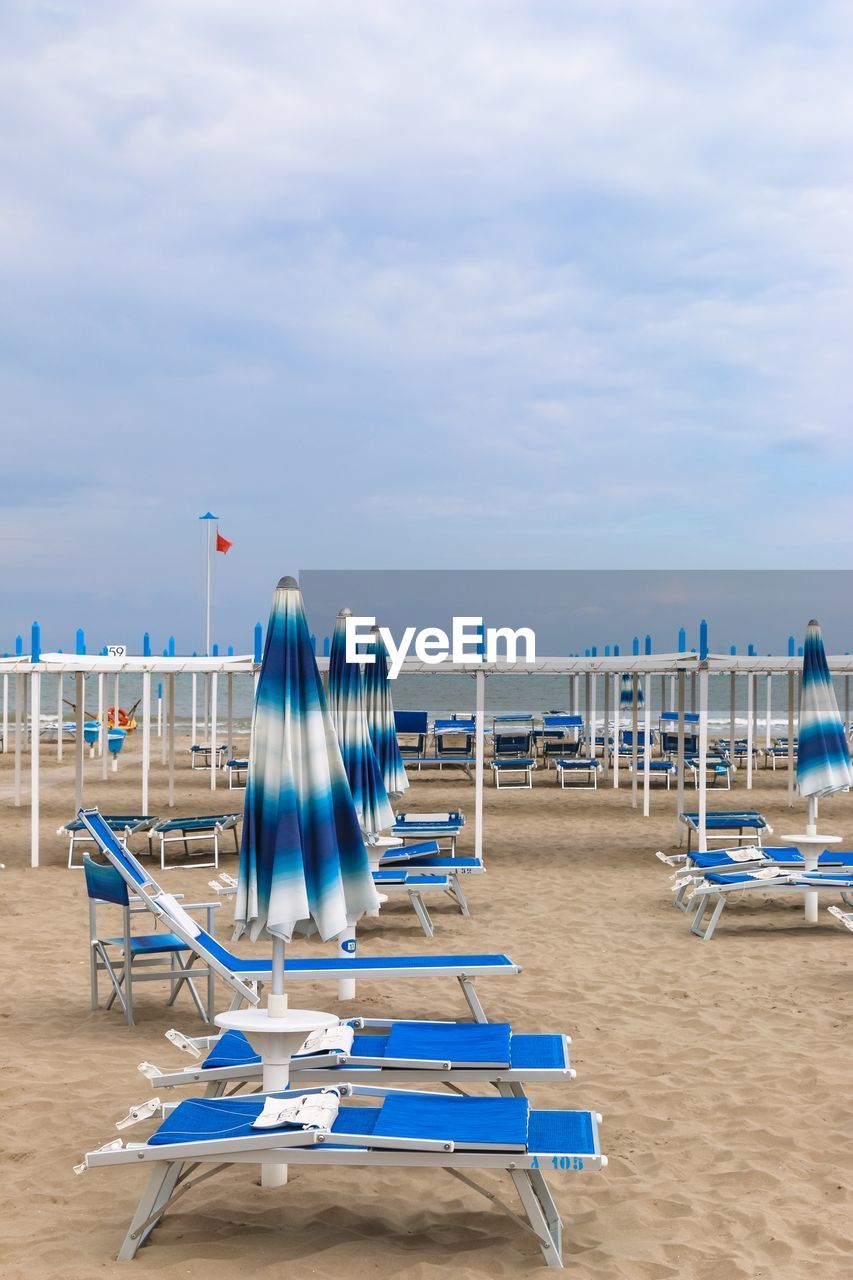 CHAIRS ON BEACH AGAINST SKY