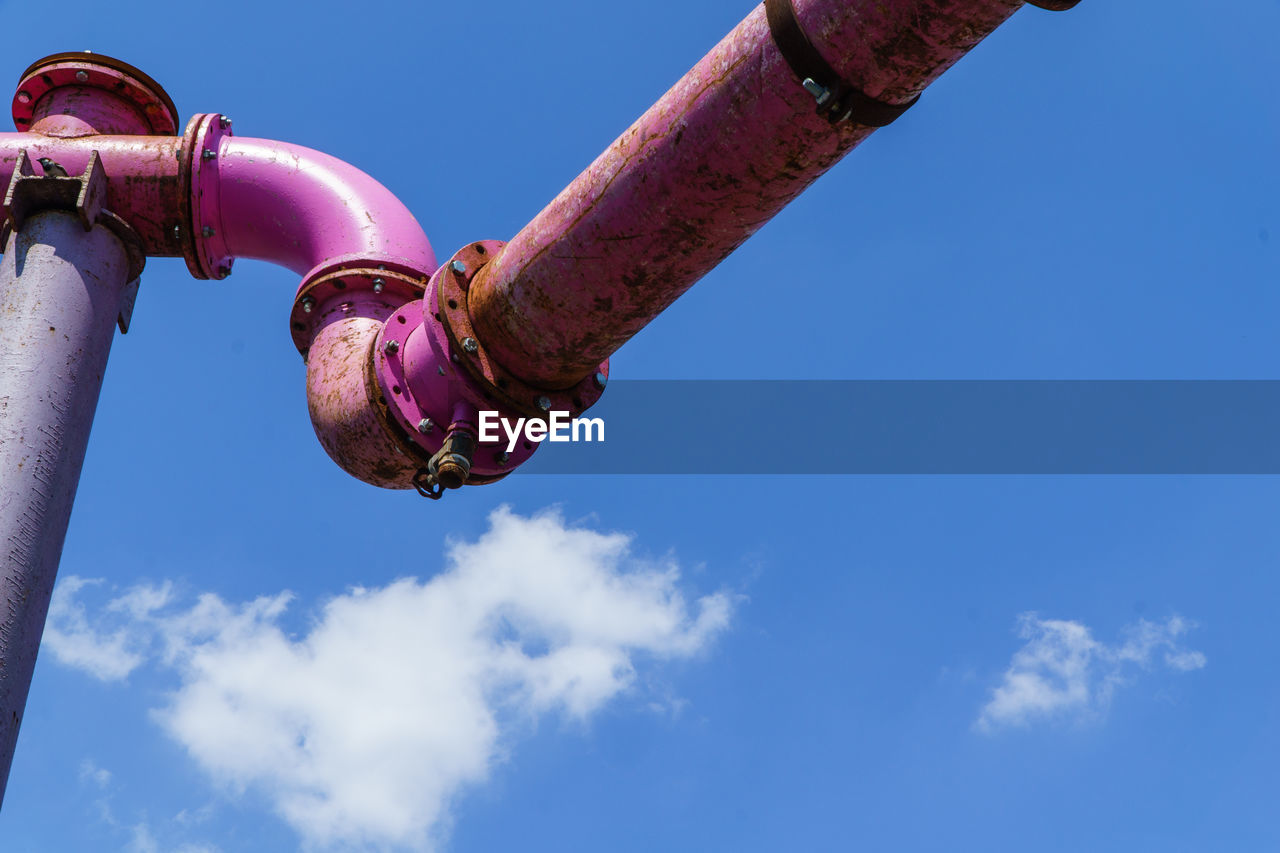 Low angle view of pipe against blue sky