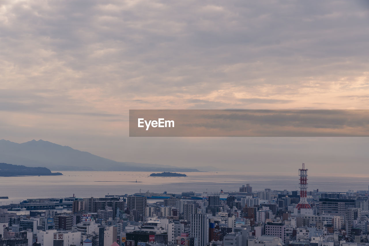 High angle view of buildings in city against cloudy sky