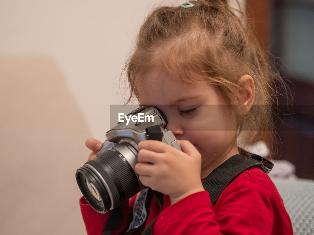 Close up of little girl looking through camera learning photography