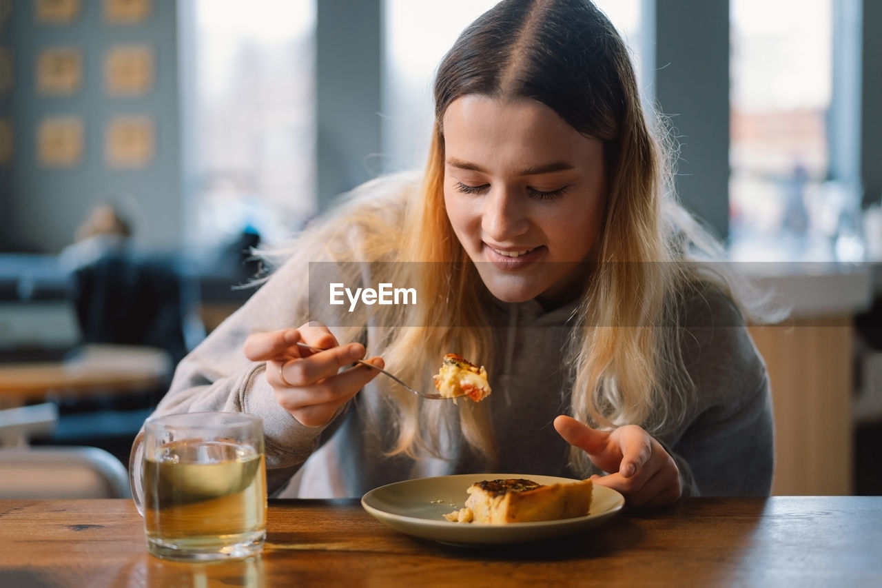 Young teengirl eating quiche with fresh vegetable