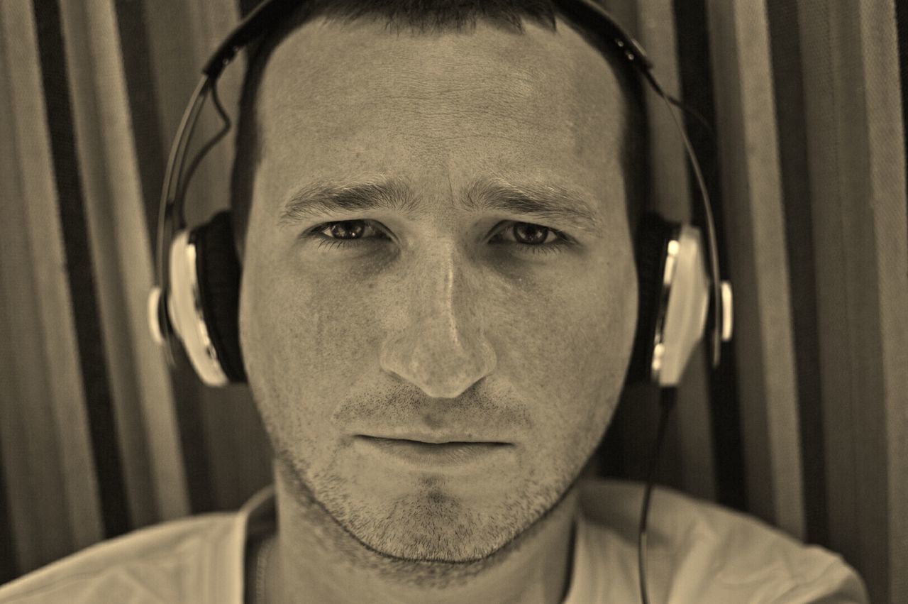 Close-up portrait of a serious young man wearing headphones