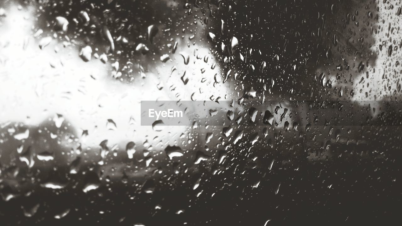 FULL FRAME SHOT OF RAINDROPS ON GLASS WINDOW