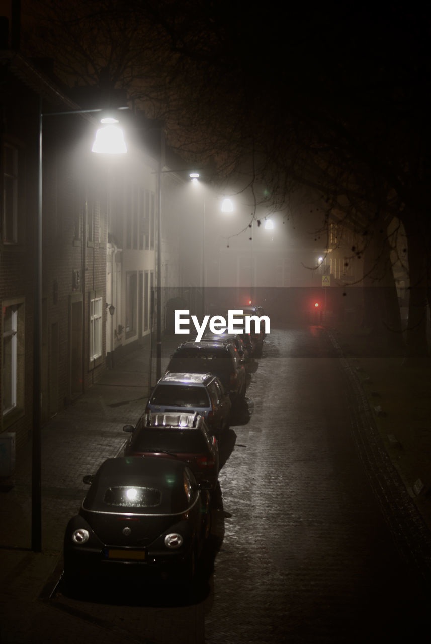 Cars on illuminated street at night