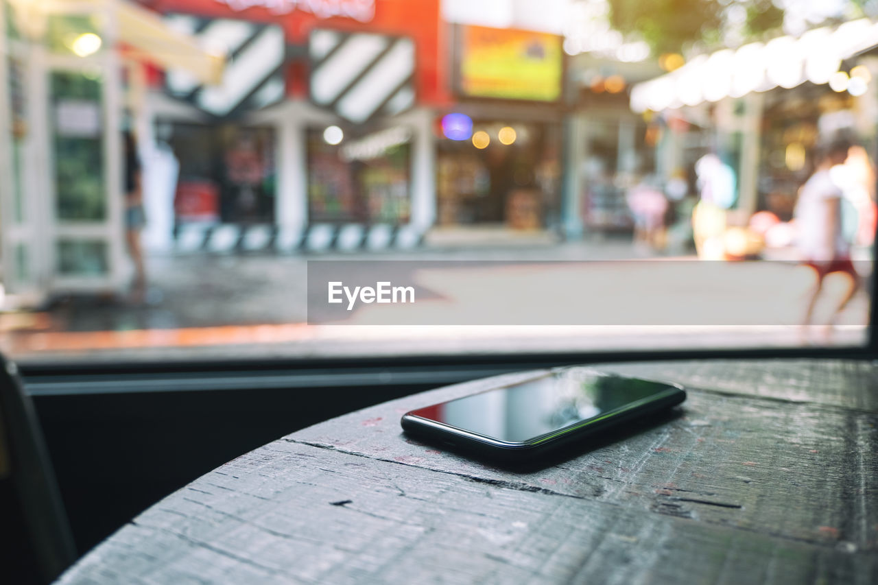 Close-up of smart phone on table at cafe