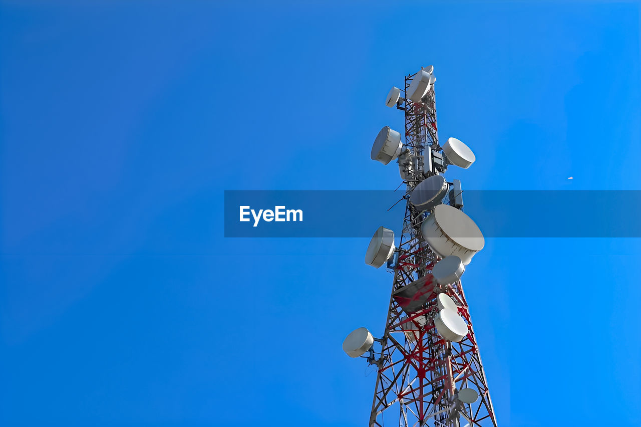 low angle view of security camera against clear blue sky