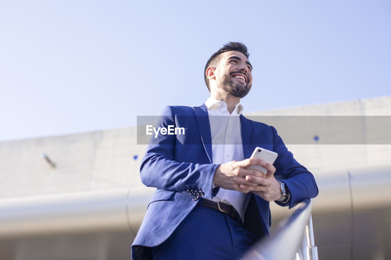 Businessman communicating with technology waiting at the airport