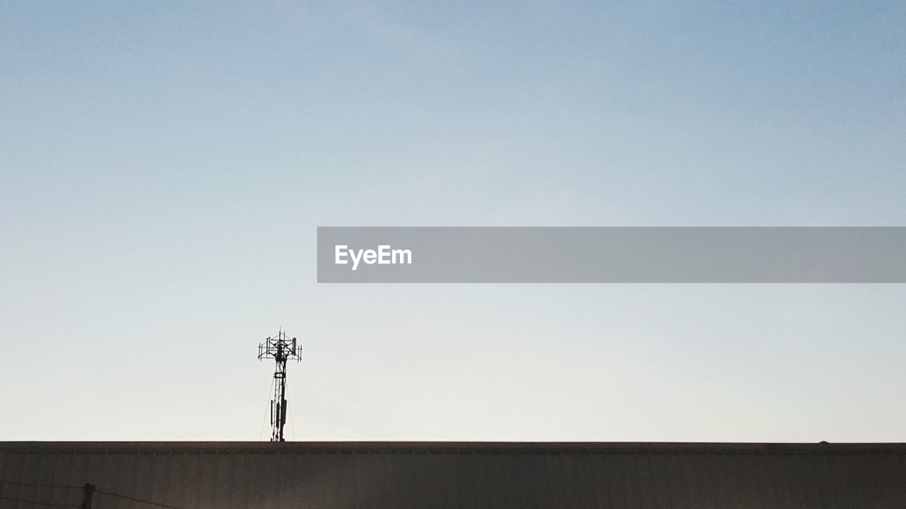 LOW ANGLE VIEW OF TELEPHONE POLE AGAINST CLEAR SKY