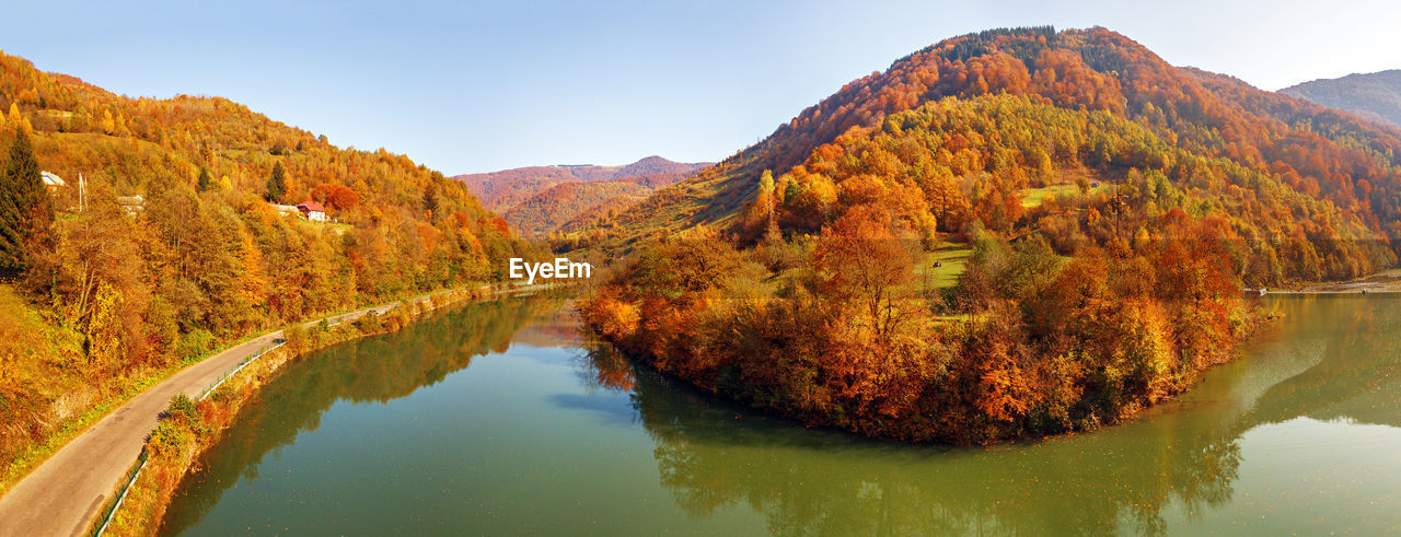 Scenic view of lake by mountain against sky during autumn