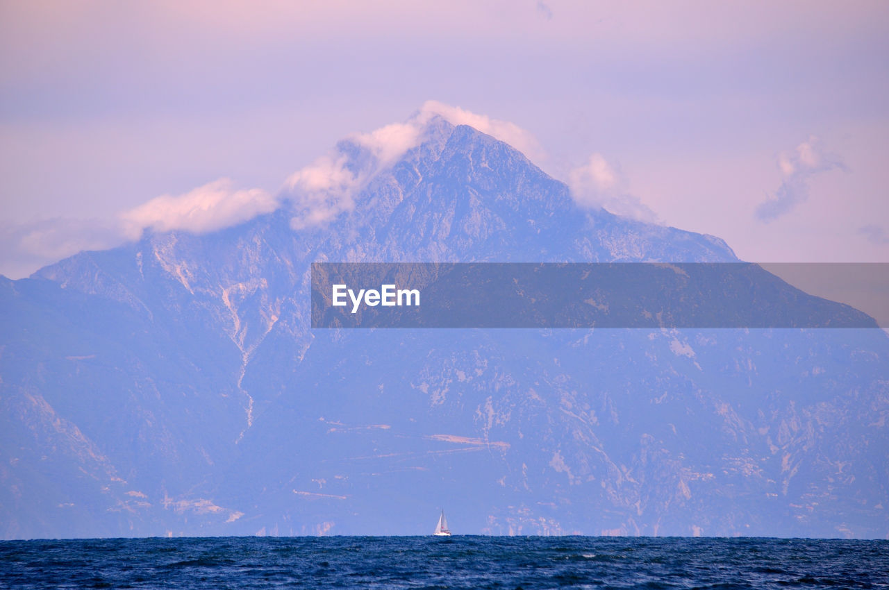 sea, water, mountain, sky, horizon, beauty in nature, cloud, scenics - nature, nature, environment, ocean, landscape, no people, travel destinations, cold temperature, travel, outdoors, snow, land, blue, tranquility, winter, dawn, mountain range, sunrise, wave, tranquil scene