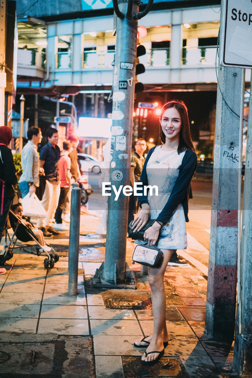 PORTRAIT OF WOMAN STANDING ON STREET