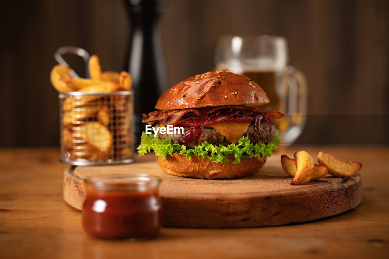 Close-up of beef burger and drink in glass on table