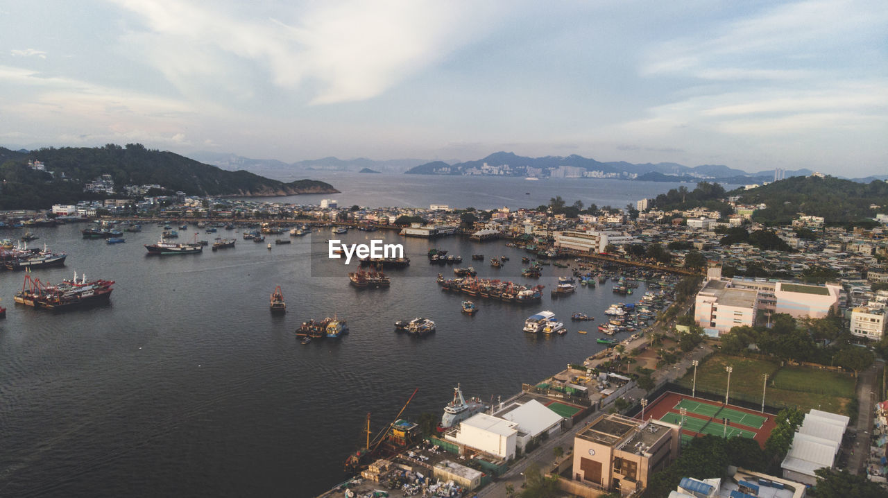 High angle view of townscape by sea against sky