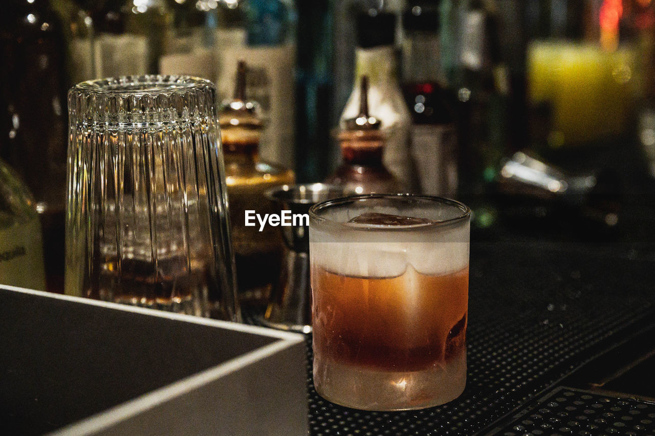 CLOSE-UP OF BEER GLASS ON TABLE AT BAR