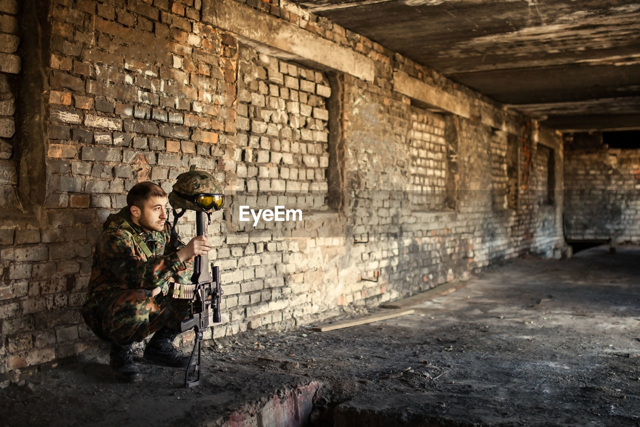 A thoughtful soldier, resting from a military operation location of ruins