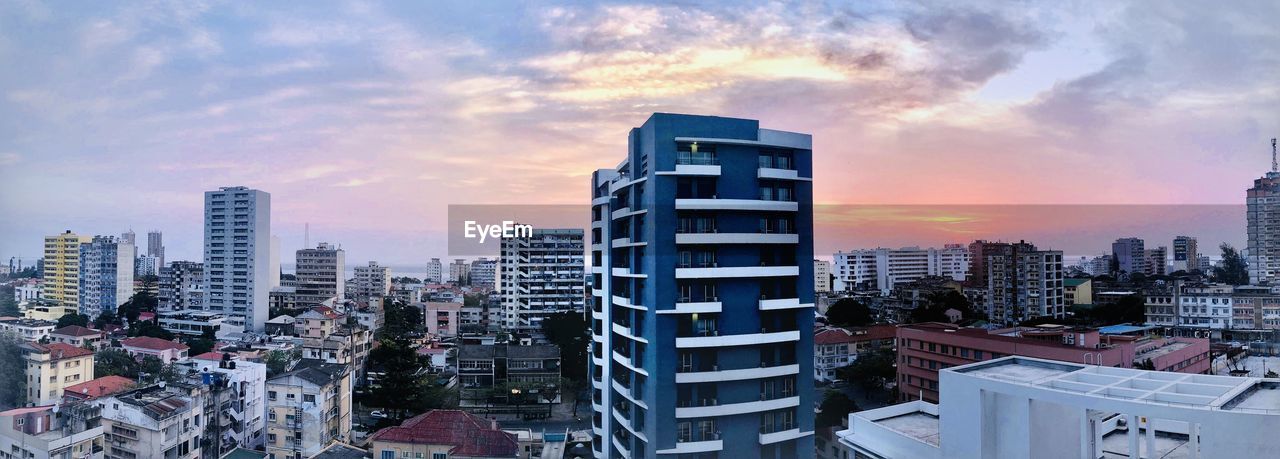 Buildings in city against sky during sunset