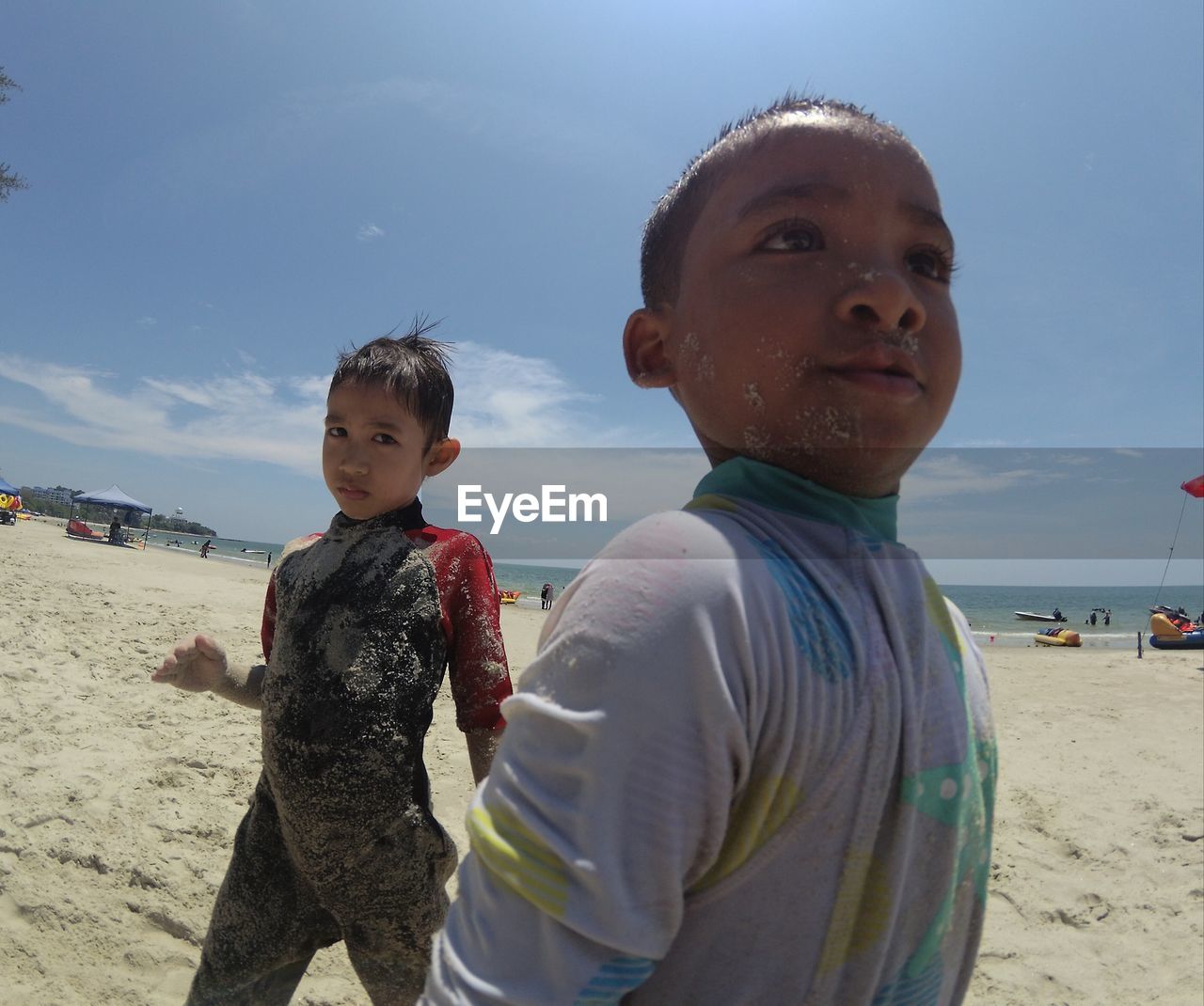 Portrait of boys at shore of beach against sky