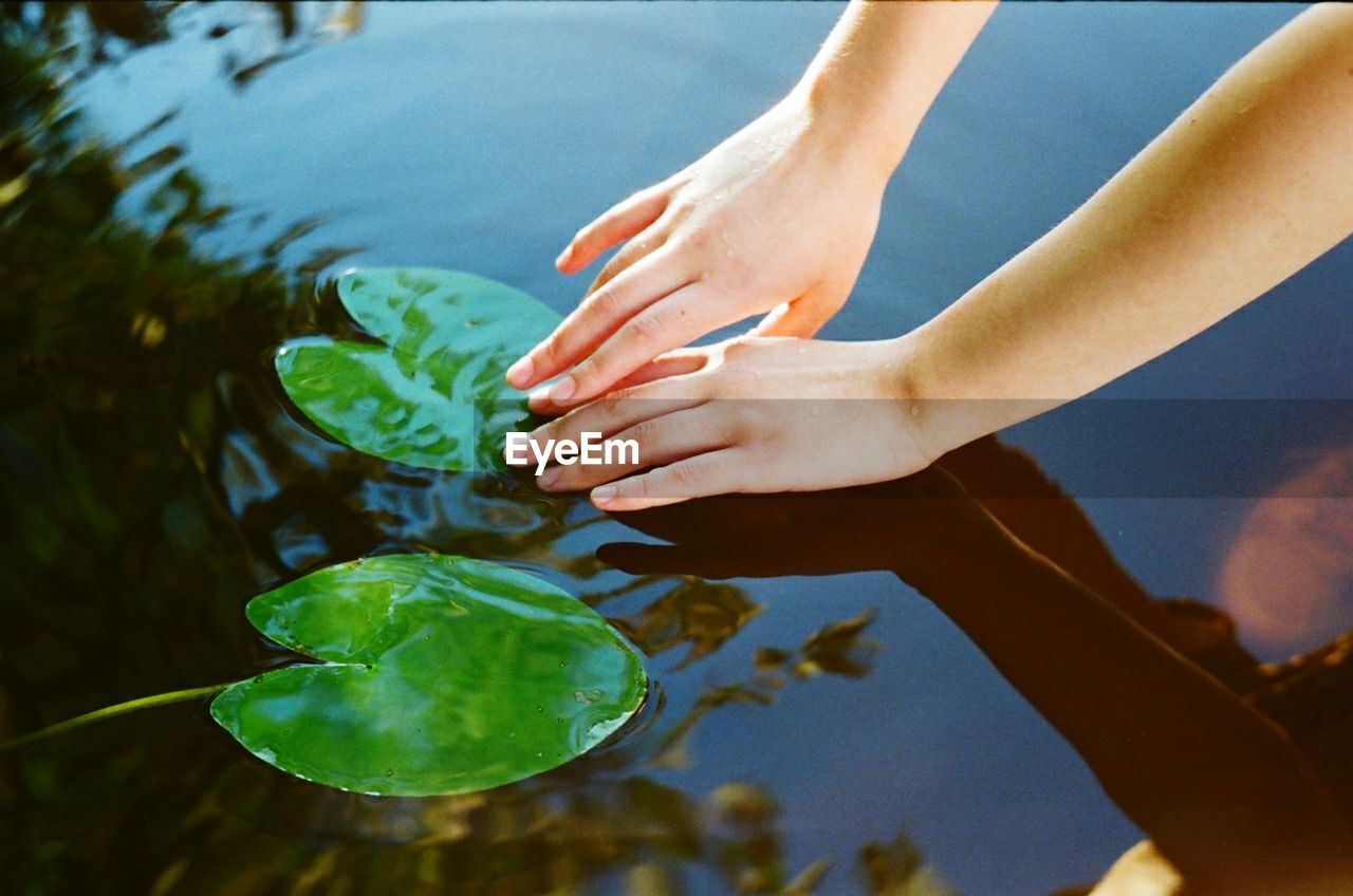 High angle view of people hands in water