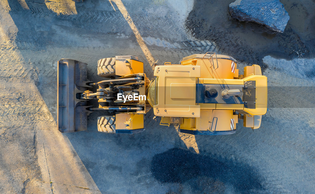 Dirrectly above shot of yellow earthmover on road
