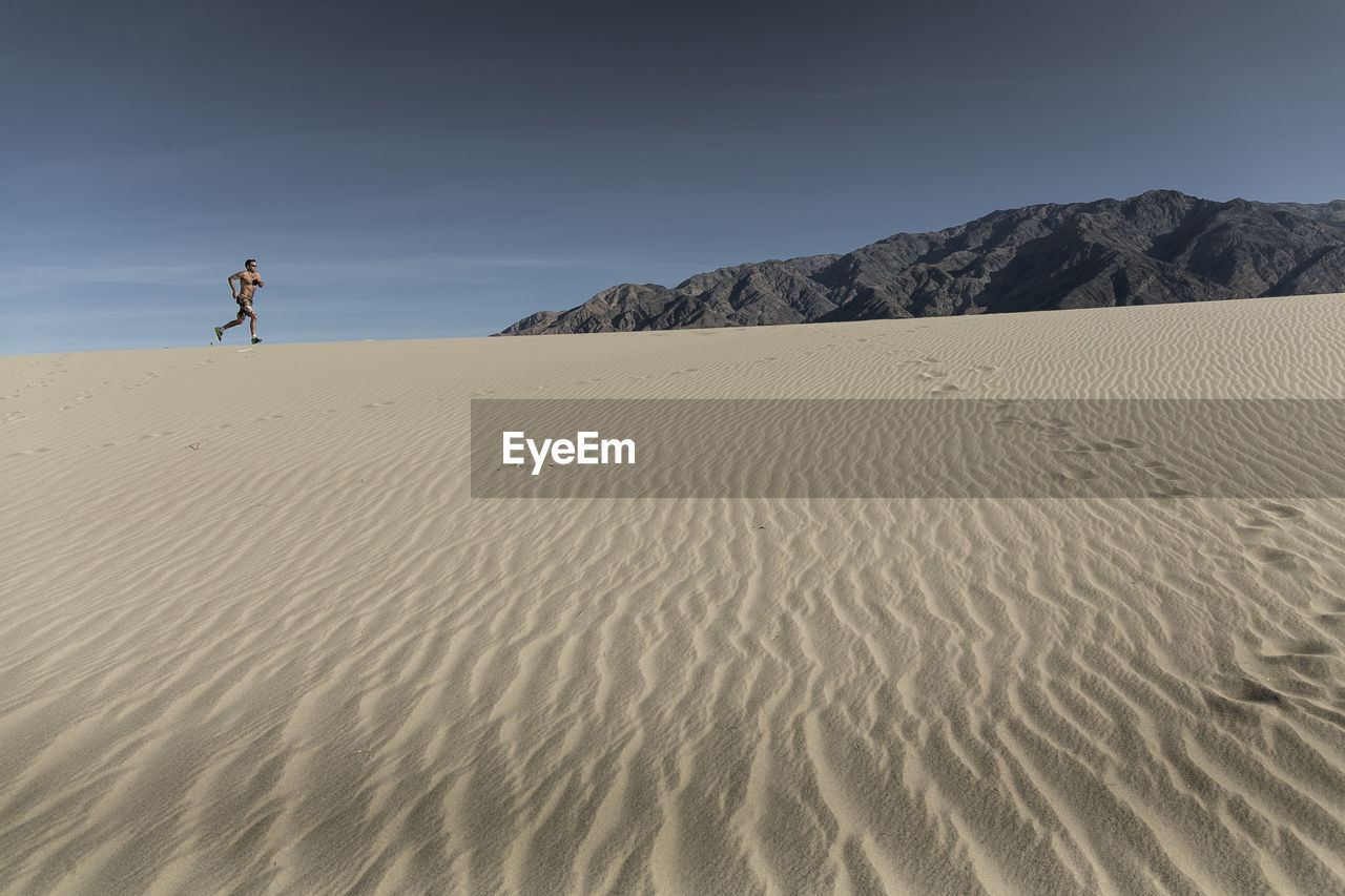 A man runs in the desert sand in death valley