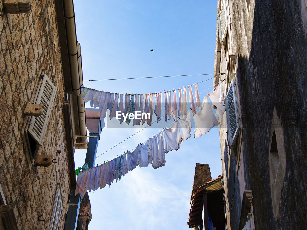 Drying clothes. low angle view of clothes drying on building against sky.