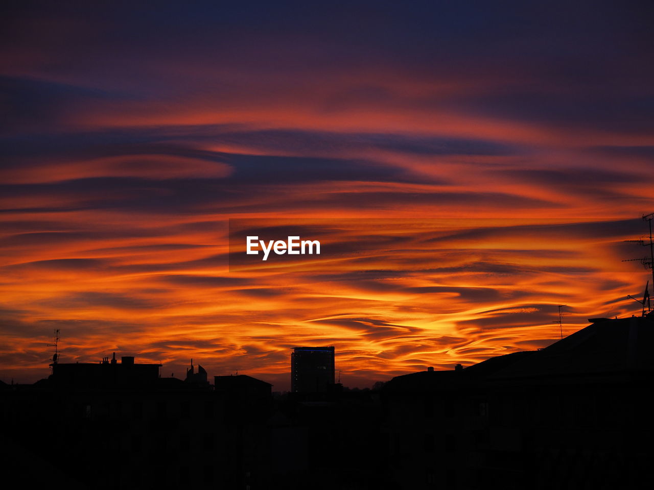 Silhouette cityscape against sky during sunset