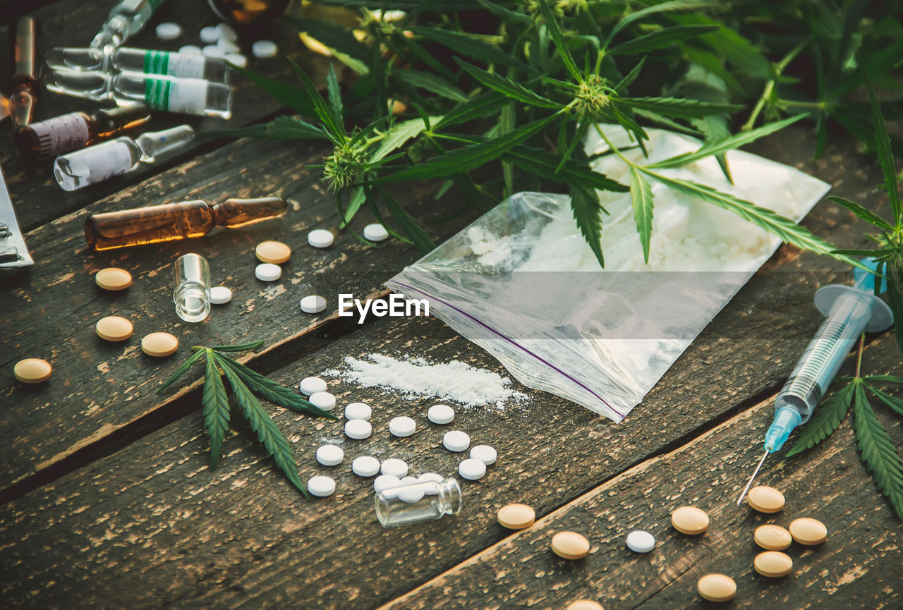 high angle view of pills spilling from bottle on table