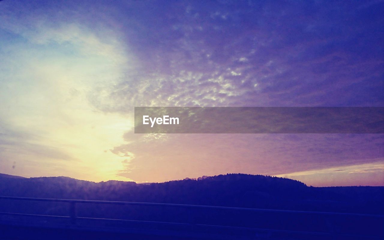 SCENIC VIEW OF SILHOUETTE MOUNTAINS AGAINST SKY DURING SUNSET