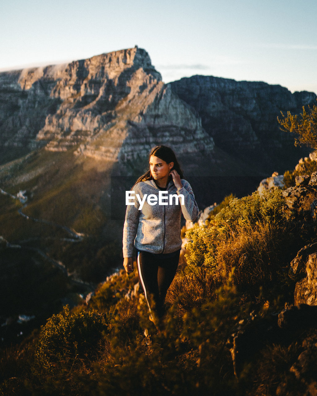 MAN STANDING ON ROCK AGAINST MOUNTAINS