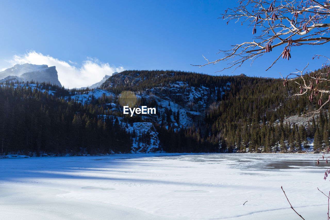 Scenic view of frozen landscape against blue sky