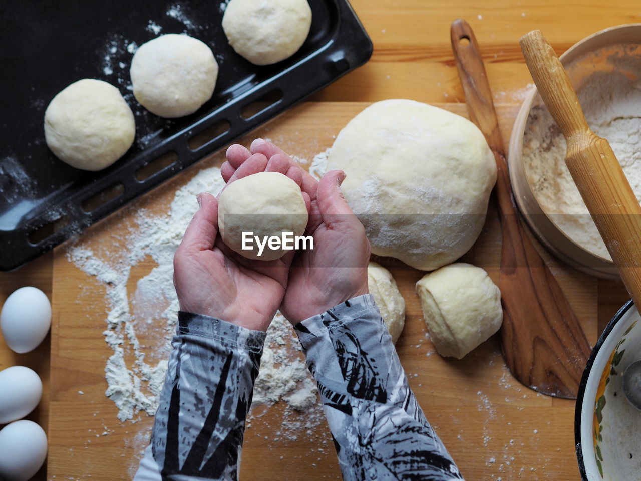 The woman's hands roll out the dough.a woman's hobby.food background.