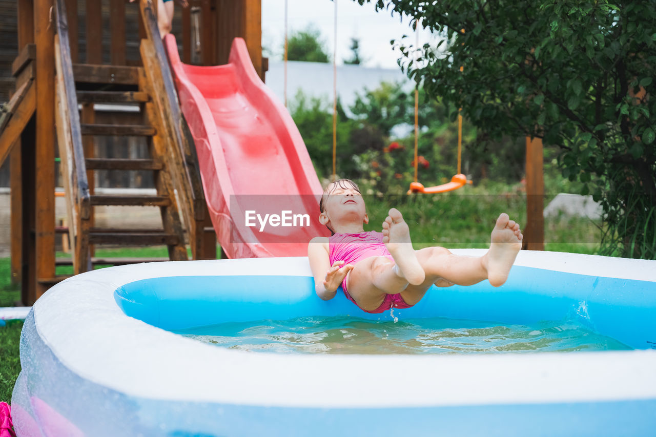 WOMAN PLAYING WITH SWIMMING POOL