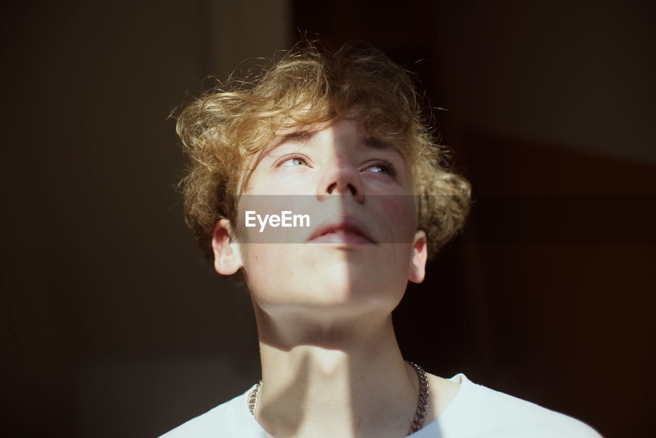 Close up of a young man looking away at home