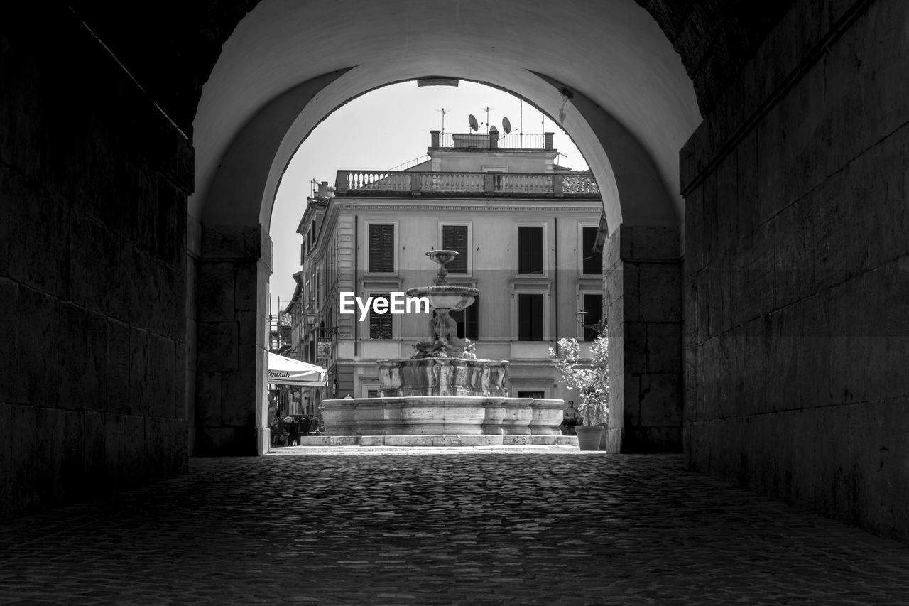 architecture, darkness, black, built structure, white, black and white, arch, monochrome, building exterior, building, light, monochrome photography, history, the past, no people, city, street, entrance, night, alley, road, cobblestone, the way forward, travel destinations, outdoors