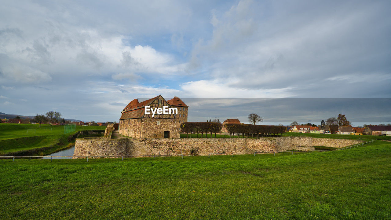 architecture, built structure, history, sky, rural area, the past, cloud, building exterior, hill, building, grass, travel destinations, nature, travel, landscape, ancient, plant, environment, tourism, land, fortification, religion, field, no people, castle, rural scene, ruins, outdoors, old, place of worship, green, château, house, wall, scenics - nature, city, medieval, fort, old ruin