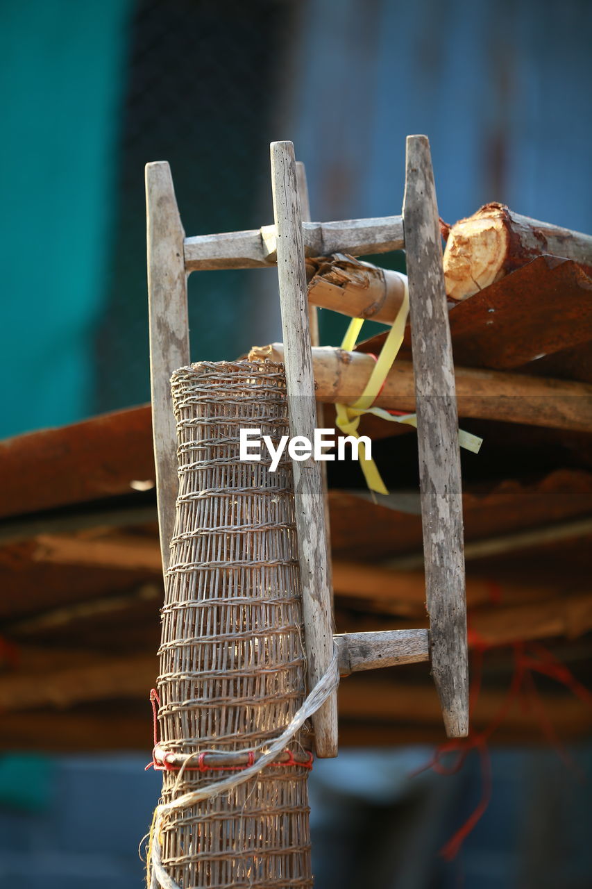 CLOSE-UP OF ROPE TIED TO WOODEN POST