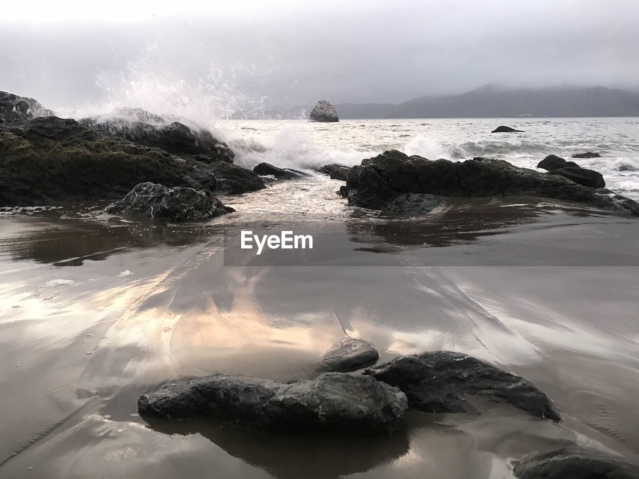 ROCKS ON BEACH AGAINST SKY