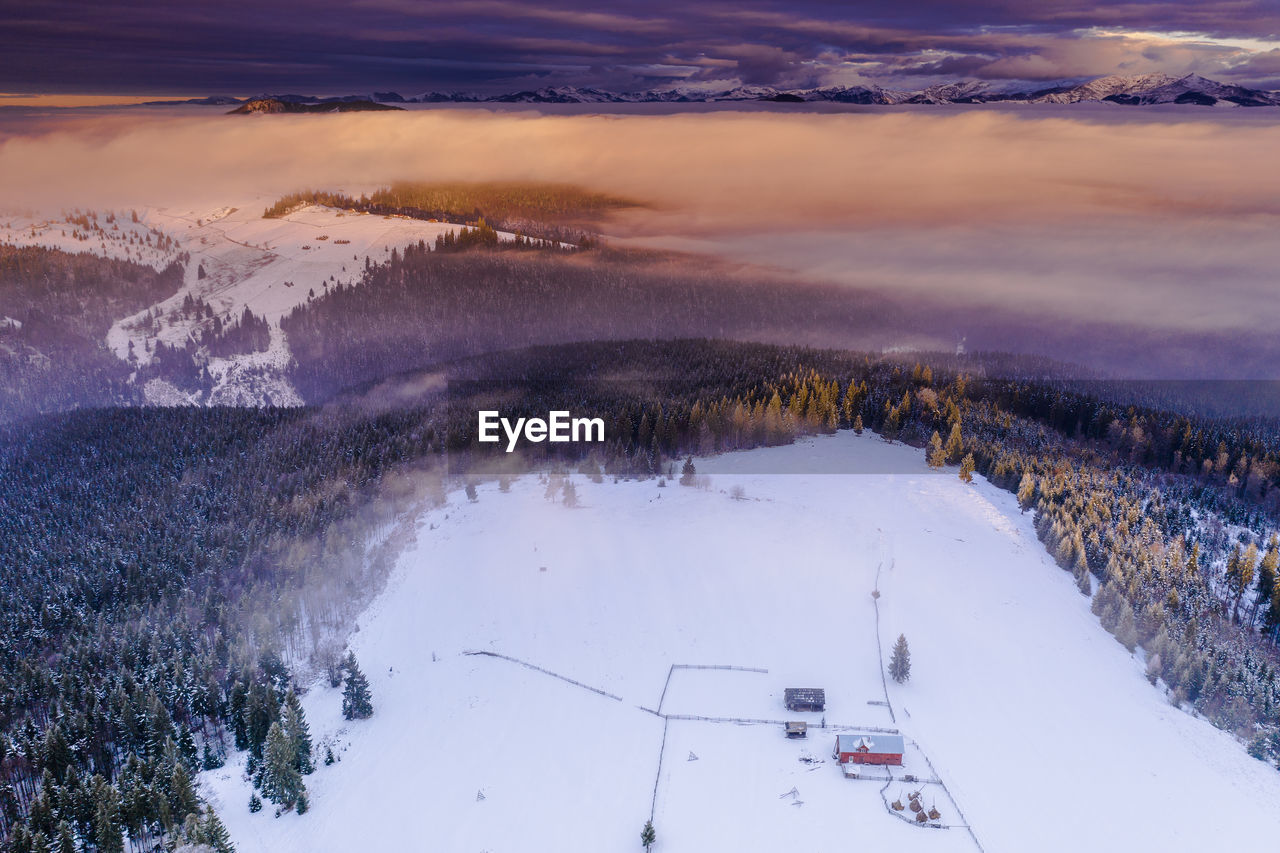 Scenic view of snow covered landscape against sky during sunset