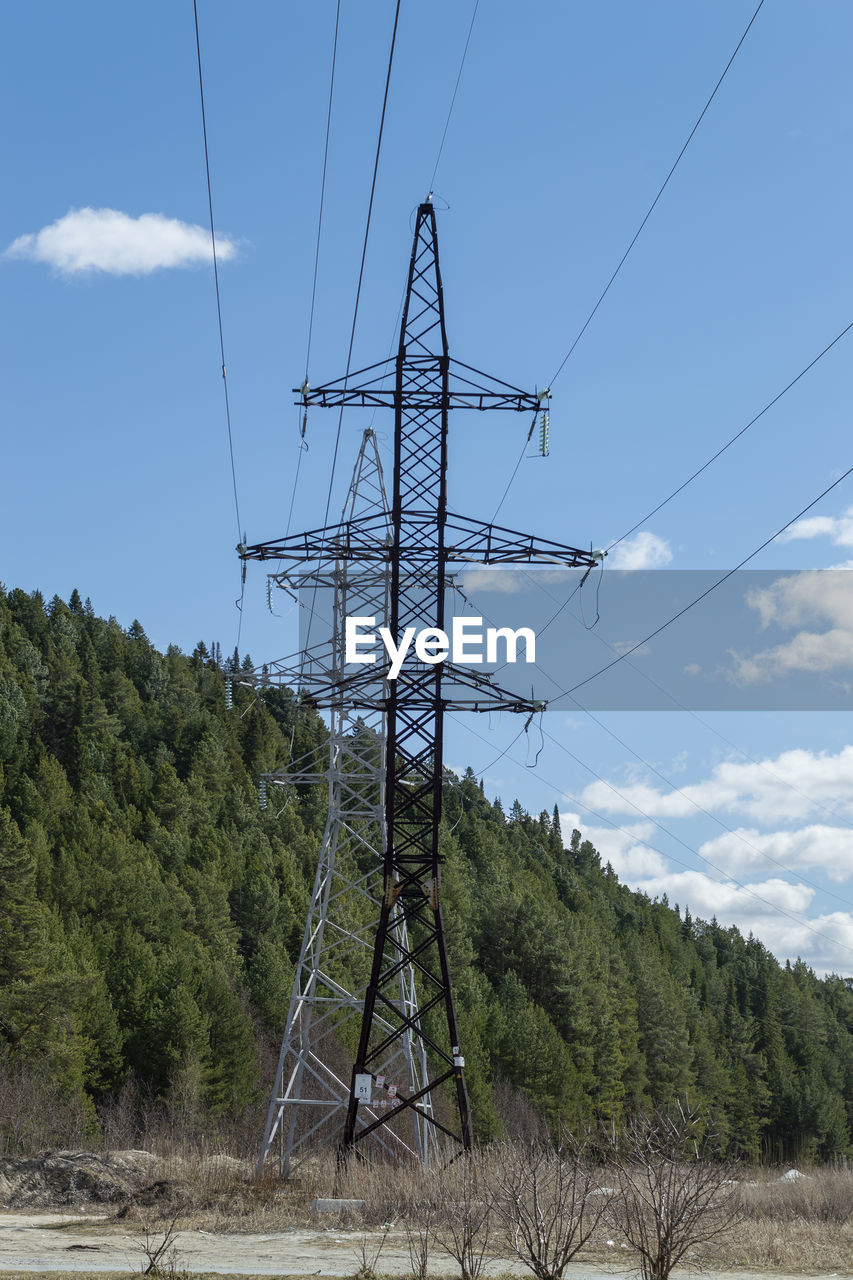 A high-voltage tower in front of the mountain. sunny good day. front view.