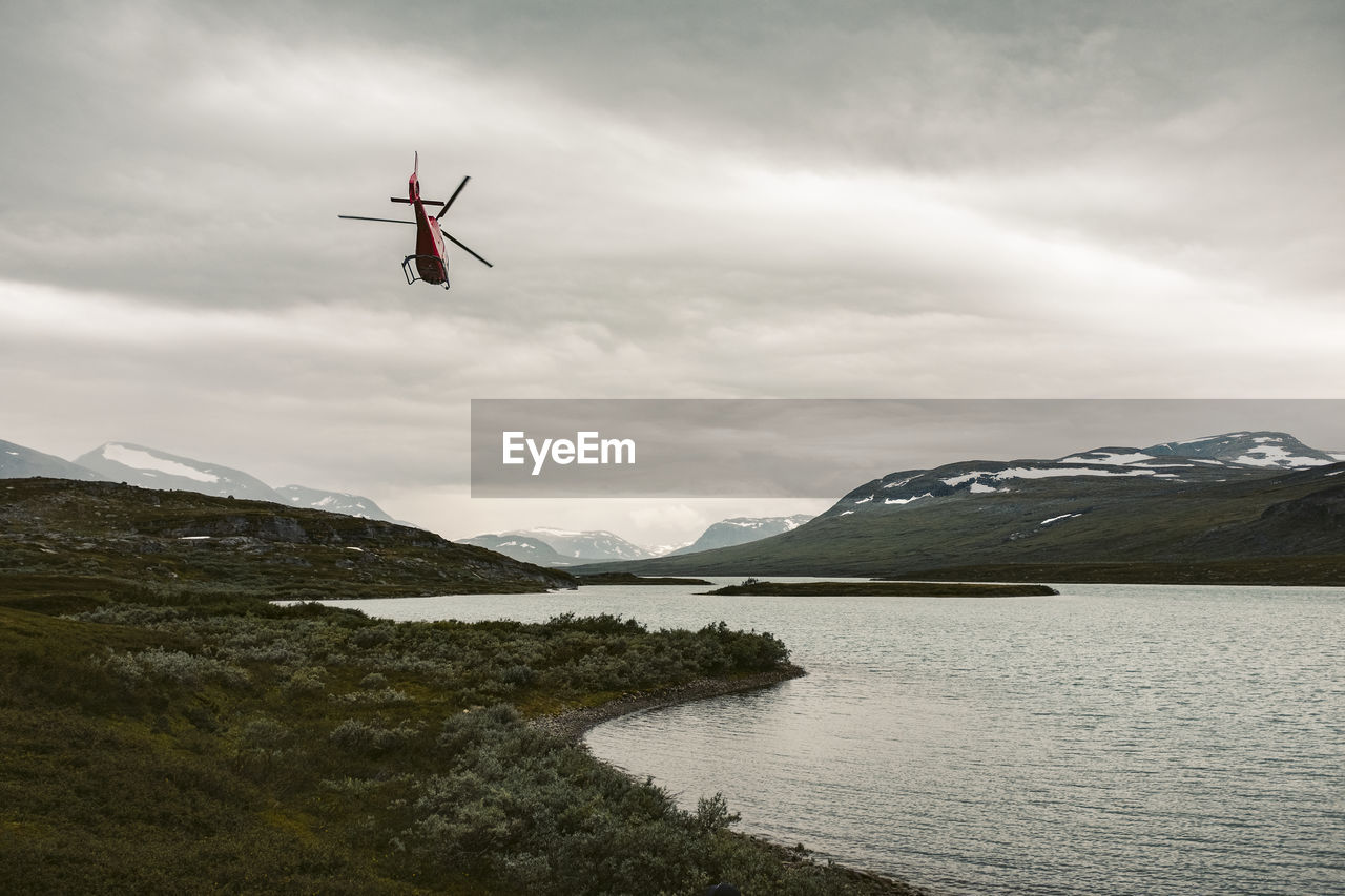 Helicopter over lake in mountains