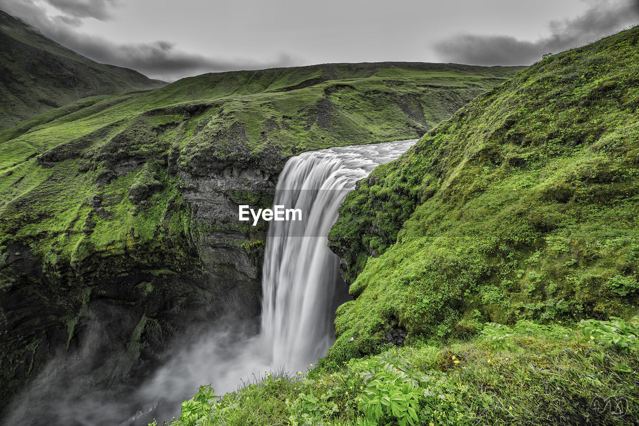 Scenic view of waterfall against sky