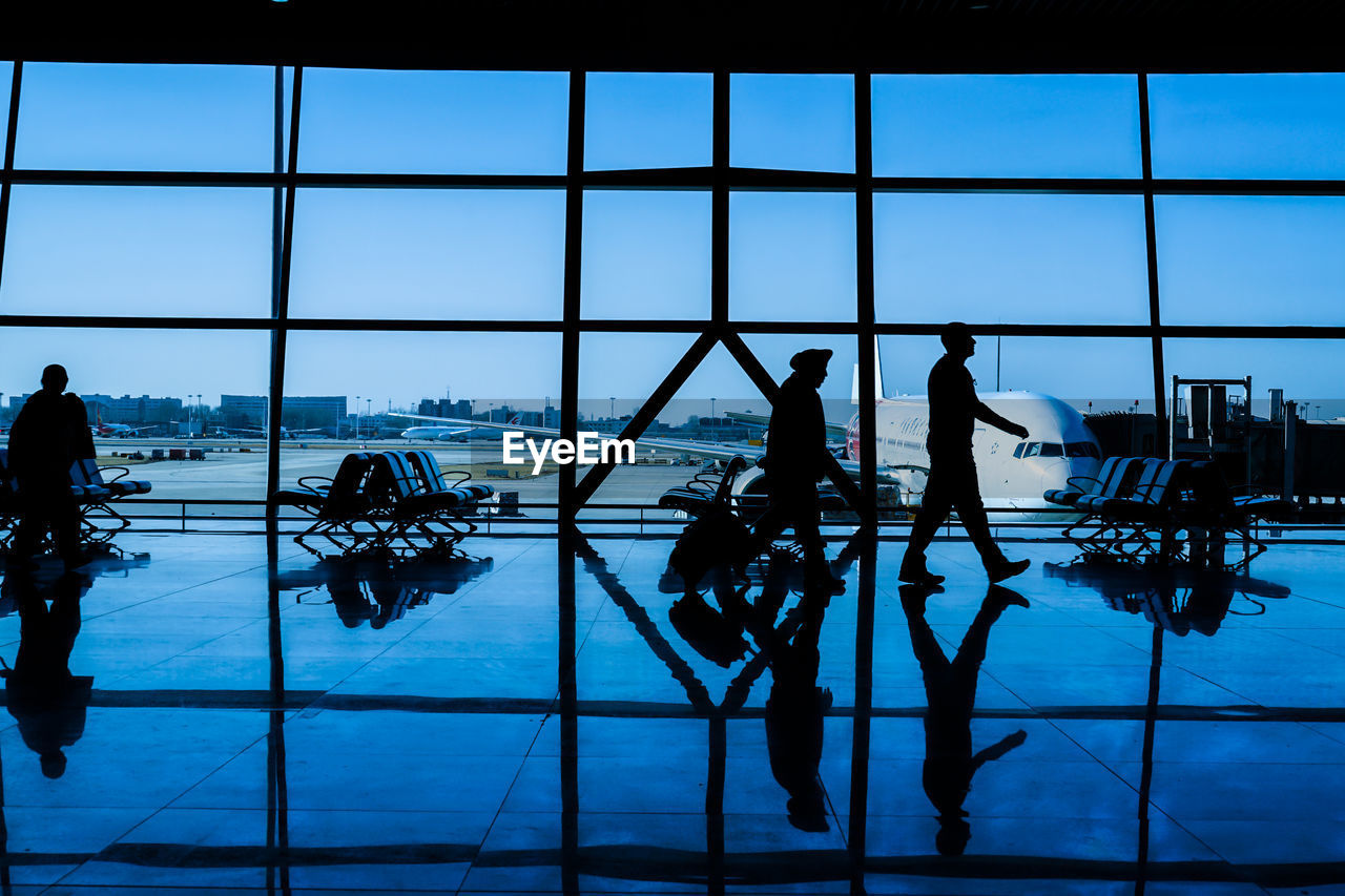 SILHOUETTE PEOPLE AGAINST SKY SEEN THROUGH WINDOW