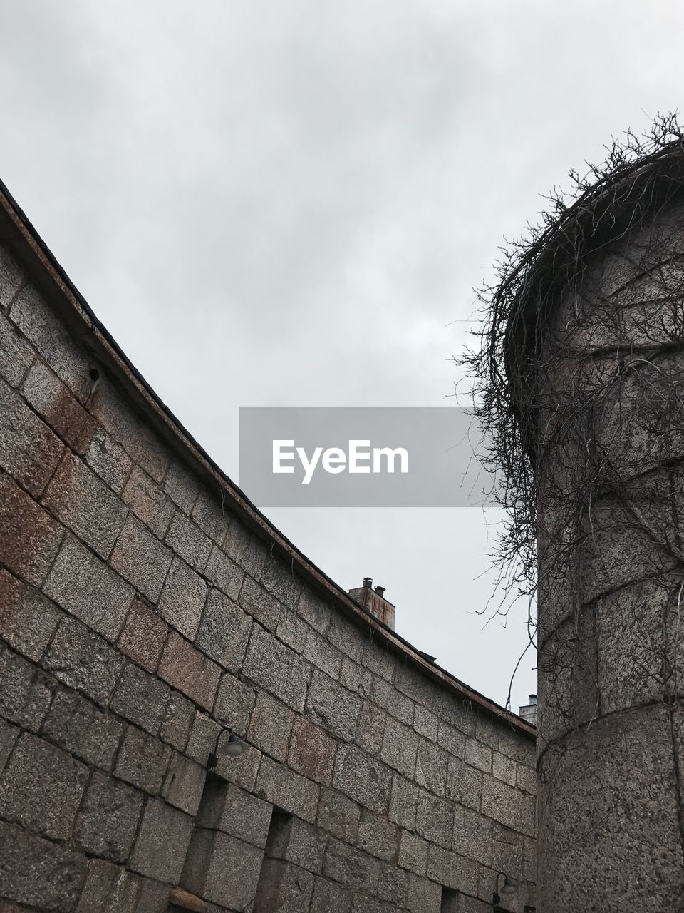 LOW ANGLE VIEW OF BRICK WALL AGAINST SKY