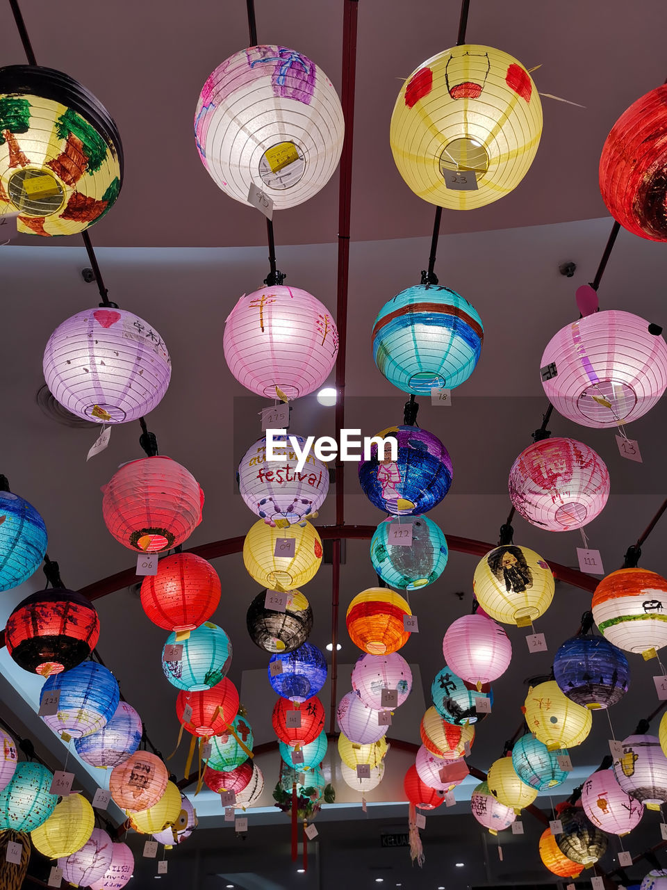 LOW ANGLE VIEW OF ILLUMINATED LANTERNS HANGING IN CEILING