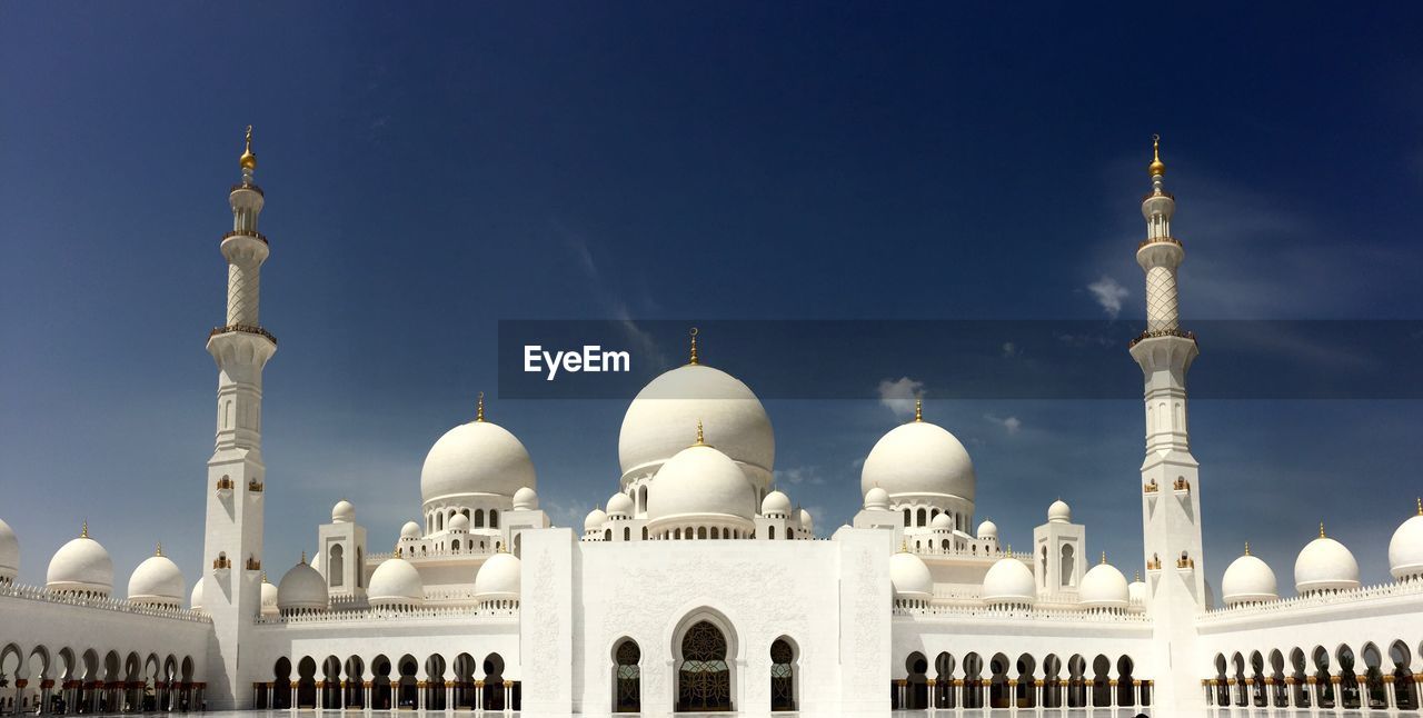 Low angle view of mosque against blue sky