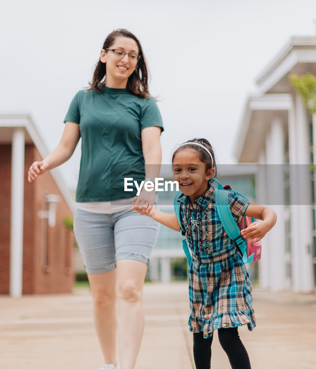 Young millennial mother sending daughter off back to school