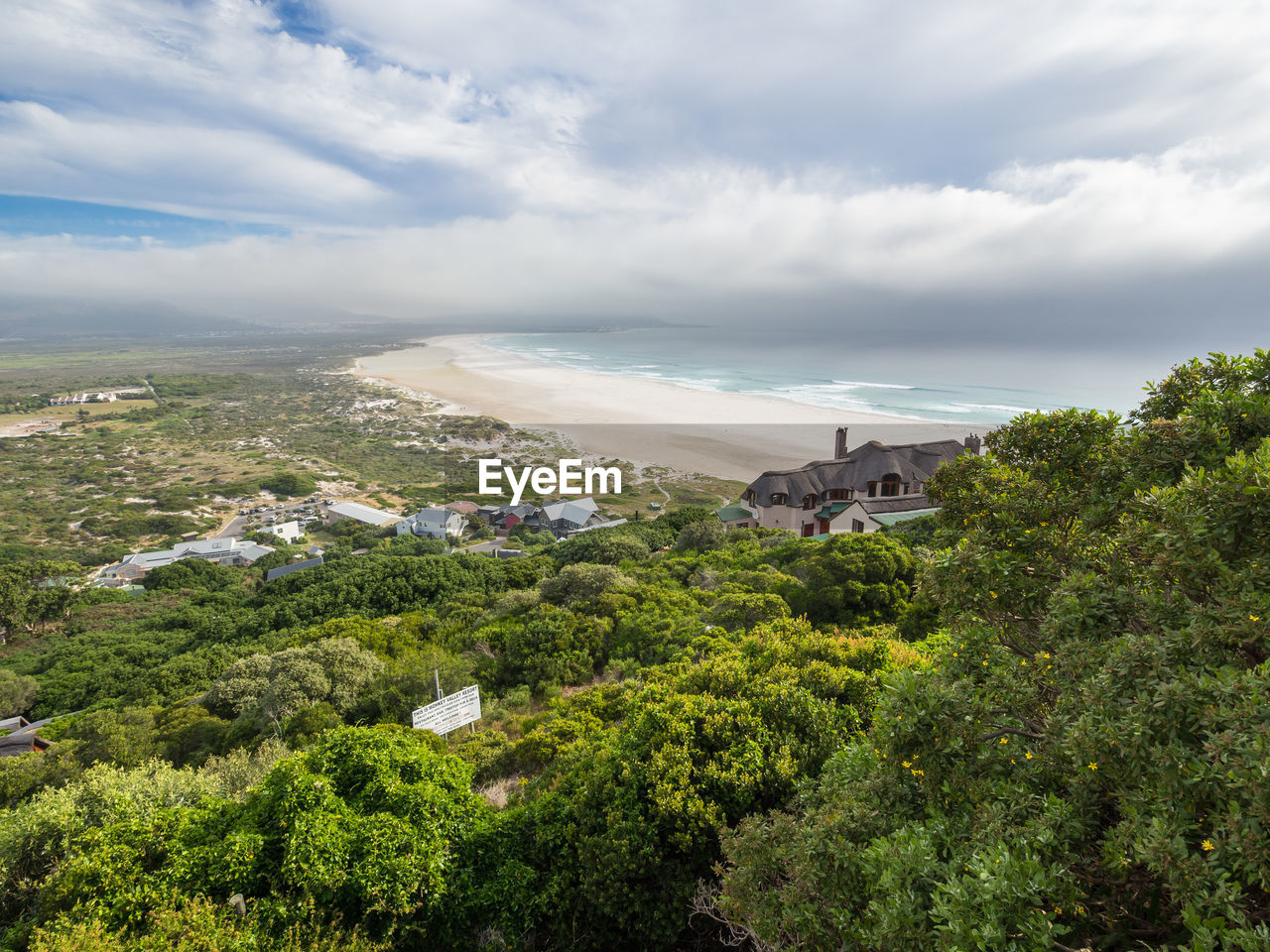 High angle view of houses by sea against sky